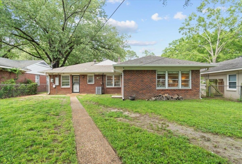 View of front of house with central AC unit and brick siding