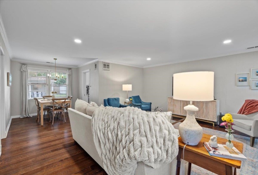 Living room with dark wood-style flooring, ornamental molding, recessed lighting, and baseboards