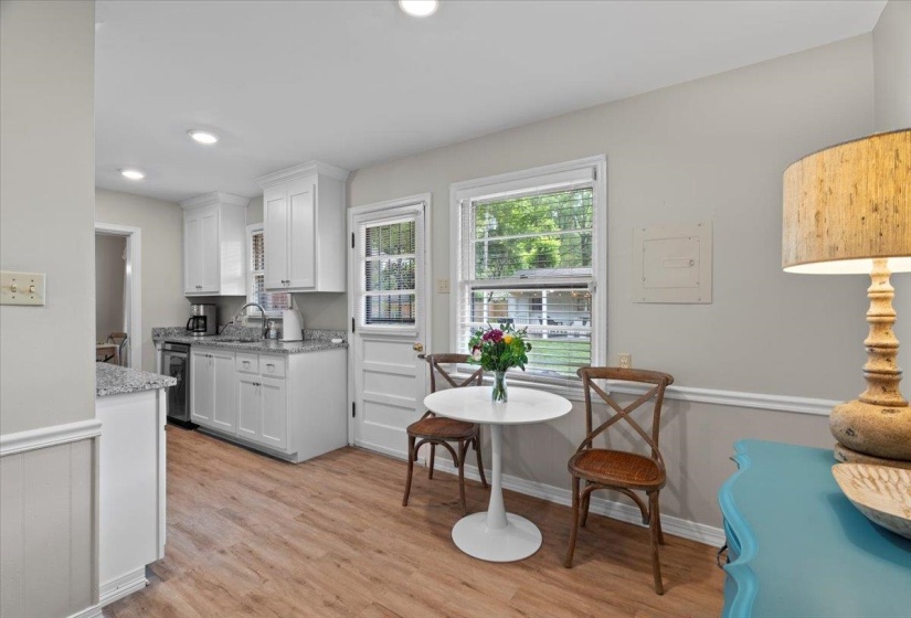 Kitchen featuring white cabinets, light wood finished floors, stainless steel dishwasher, a sink, and recessed lighting