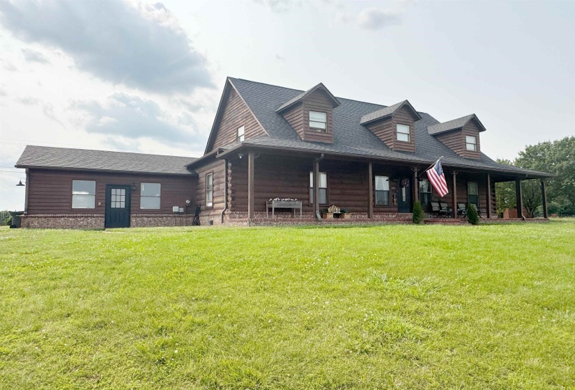 View of front of property with roof with shingles, a front lawn, and a porch