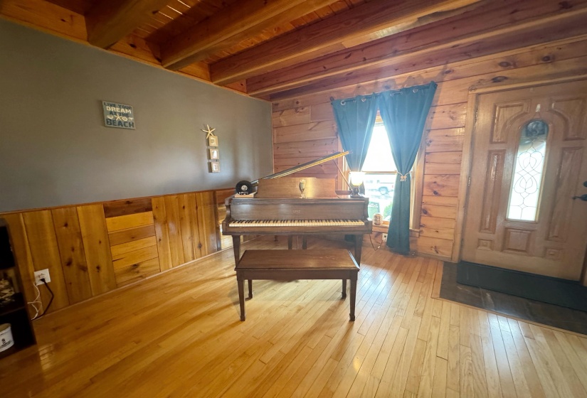 Entrance foyer featuring wood walls, hardwood / wood-style floors, and wooden ceiling with exposed beams