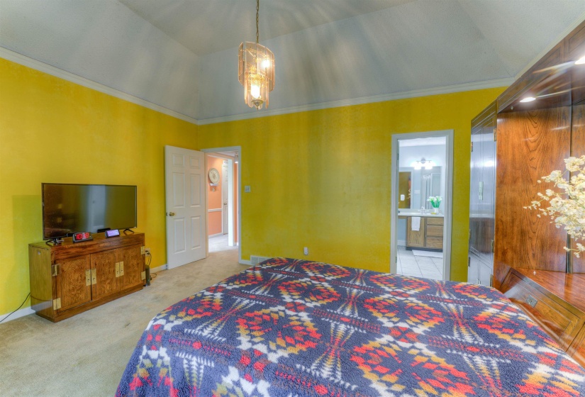 Bedroom with carpet floors, connected bathroom, baseboards, and crown molding