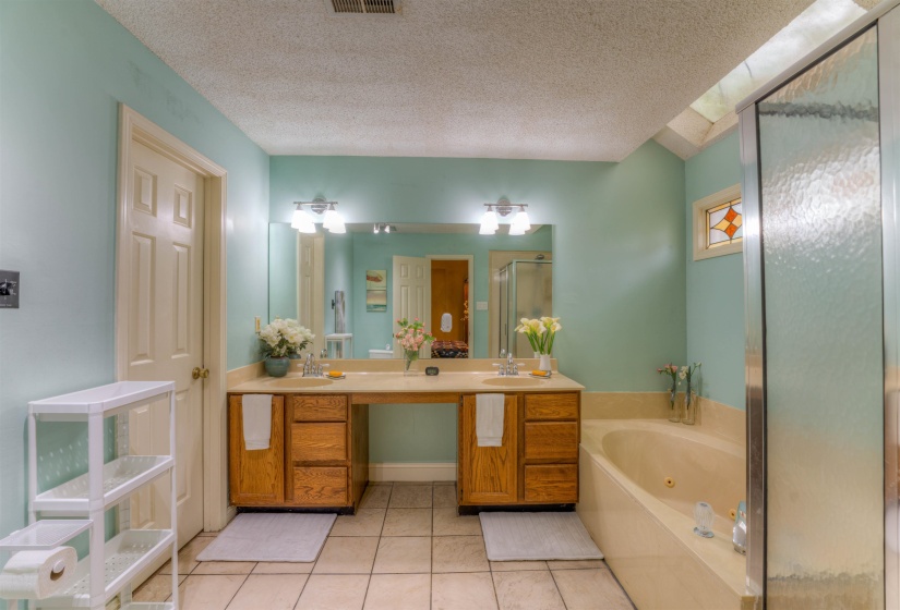 Bathroom with a shower stall, double vanity, a jetted tub, tile patterned floors, and a textured ceiling