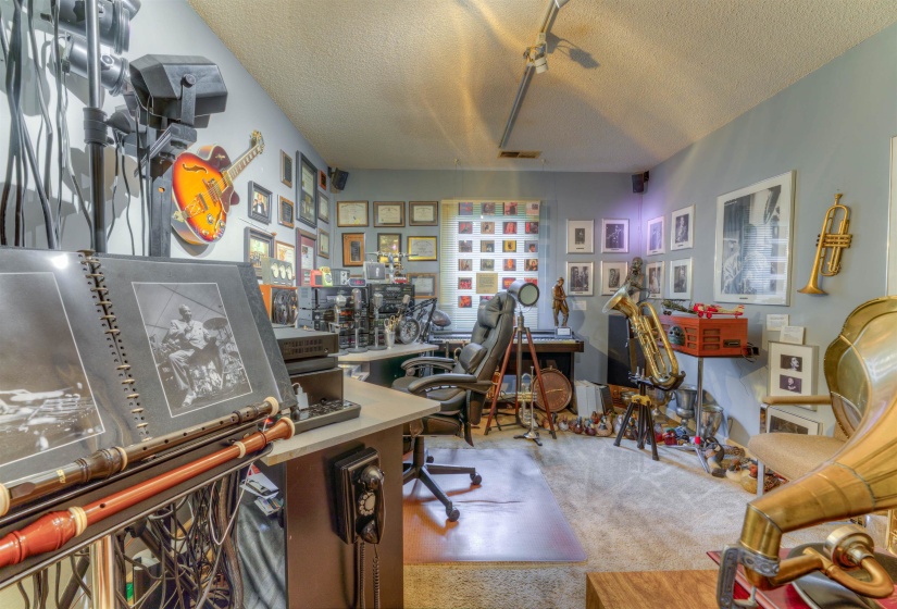 Carpeted office space with a textured ceiling