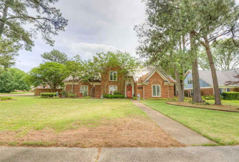 Traditional home with a front yard and brick siding
