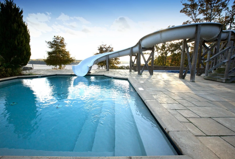 View of pool featuring a water slide and a patio