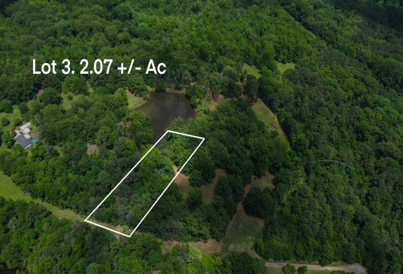 Aerial view of property and surrounding area with a heavily wooded area and property parcel outlined