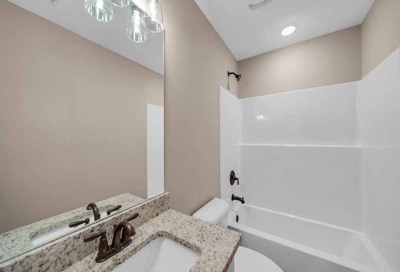 Bathroom with toilet, shower / bathtub combination, and vanity