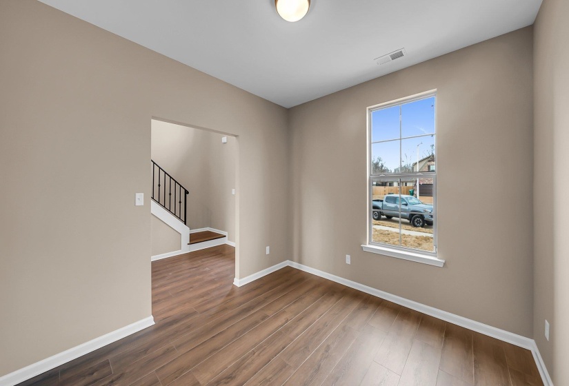 Spare room with dark wood-style floors, stairs, and baseboards