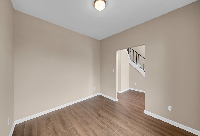 Empty room with stairway, baseboards, and wood finished floors