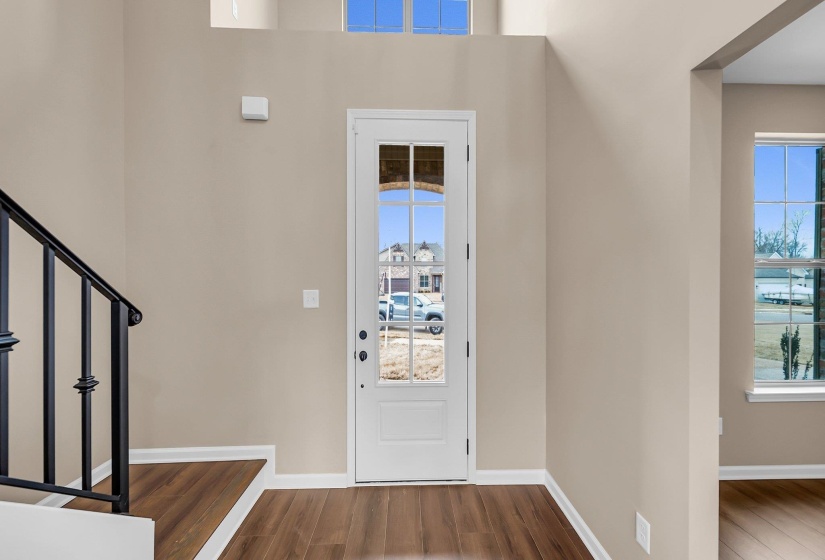 Entryway featuring stairway, baseboards, and wood finished floors