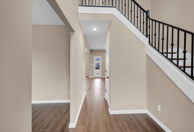 Hall featuring a high ceiling, dark wood finished floors, and baseboards