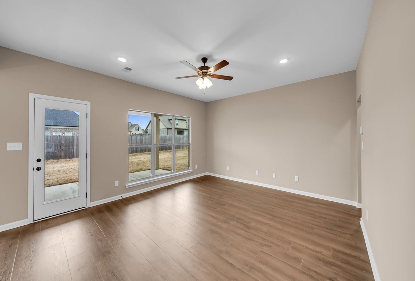 Empty room with ceiling fan, wood finished floors, visible vents, and baseboards