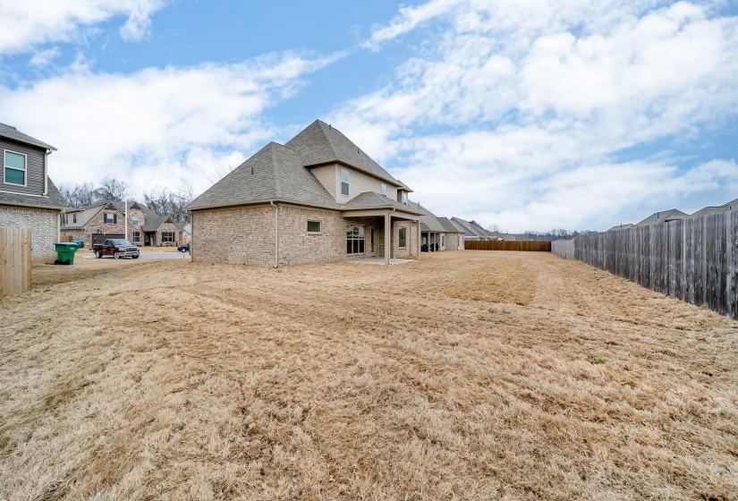 Rear view of property featuring a shingled roof and fence
