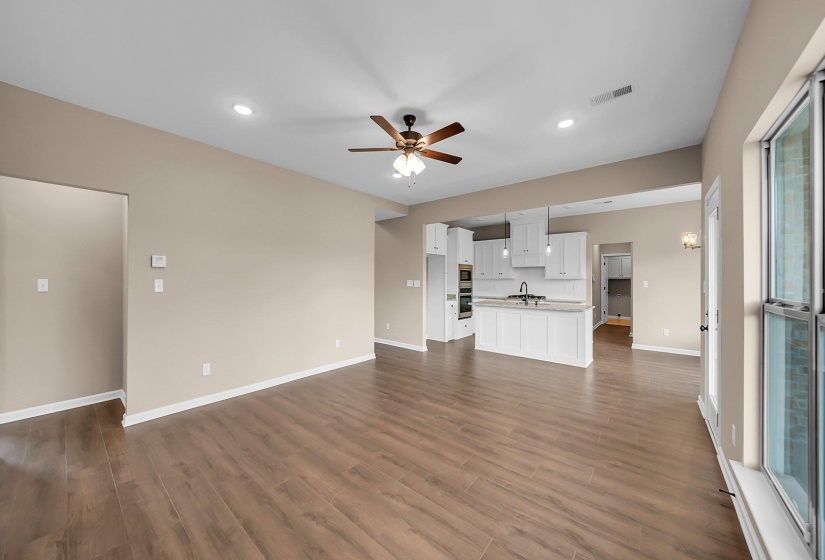 Unfurnished living room with dark wood-style flooring, recessed lighting, visible vents, a ceiling fan, and baseboards