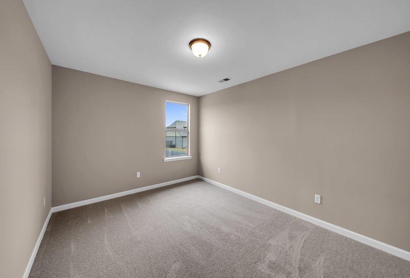 Carpeted empty room with visible vents and baseboards