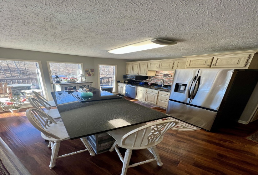 Kitchen featuring dark hardwood / wood-style flooring, cream cabinets, a breakfast bar area, and appliances with stainless steel finishes