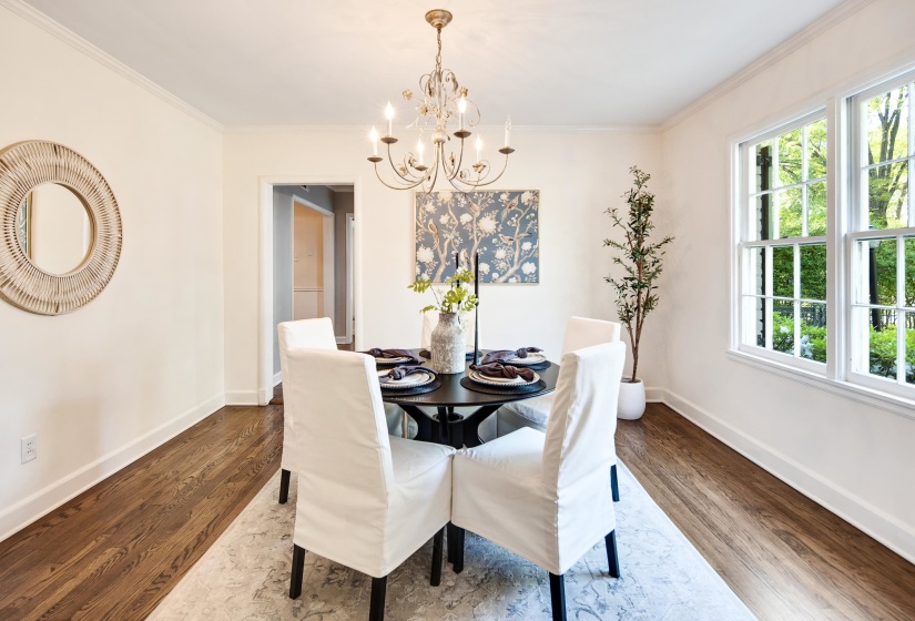 Dining room with baseboards, an inviting chandelier, dark wood-type flooring, and crown molding