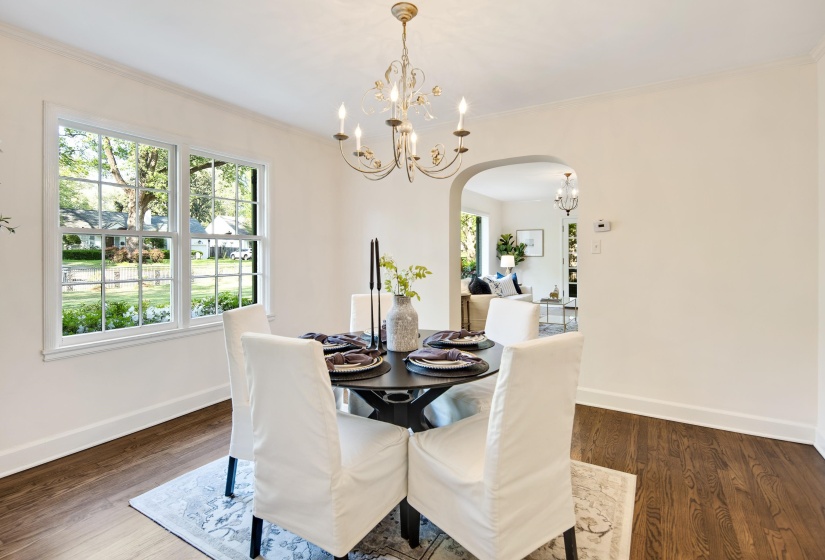 Dining room featuring arched walkways, crown molding, a chandelier, and baseboards