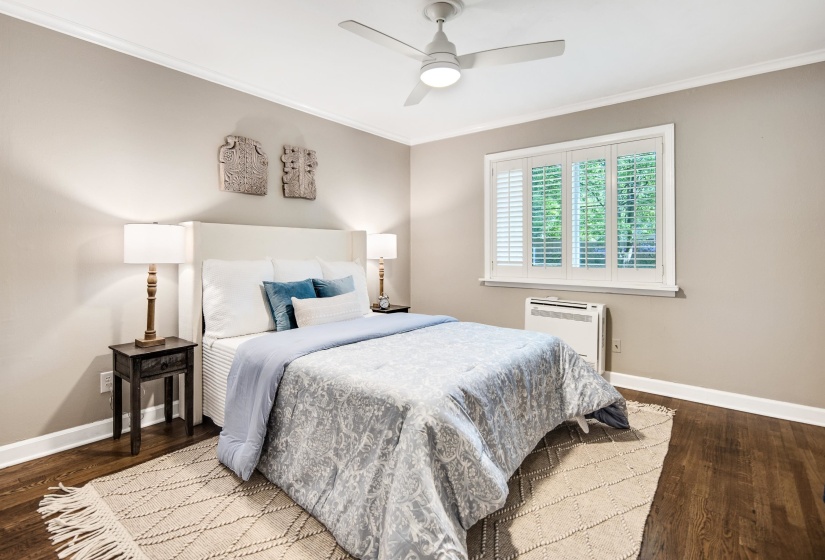 Bedroom with wood finished floors, baseboards, and ornamental molding