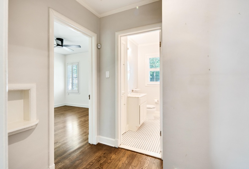 Corridor with dark wood finished floors, a healthy amount of sunlight, crown molding, and baseboards