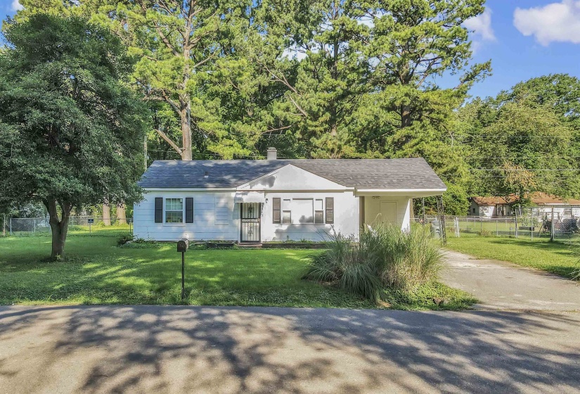 View of front of house featuring driveway, roof with shingles, and an attached carport