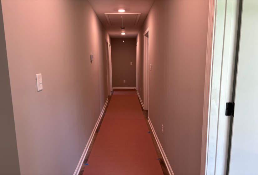 Corridor with attic access and baseboards