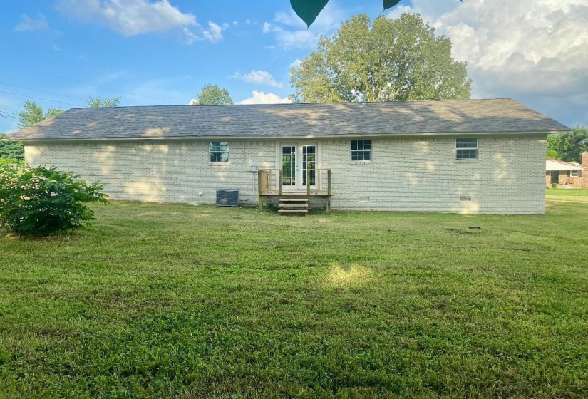 Back of property with french doors, brick siding, and crawl space