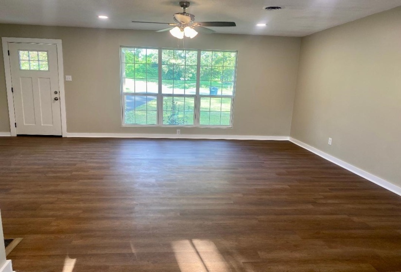 Unfurnished living room featuring a ceiling fan, dark wood-style flooring, and recessed lighting