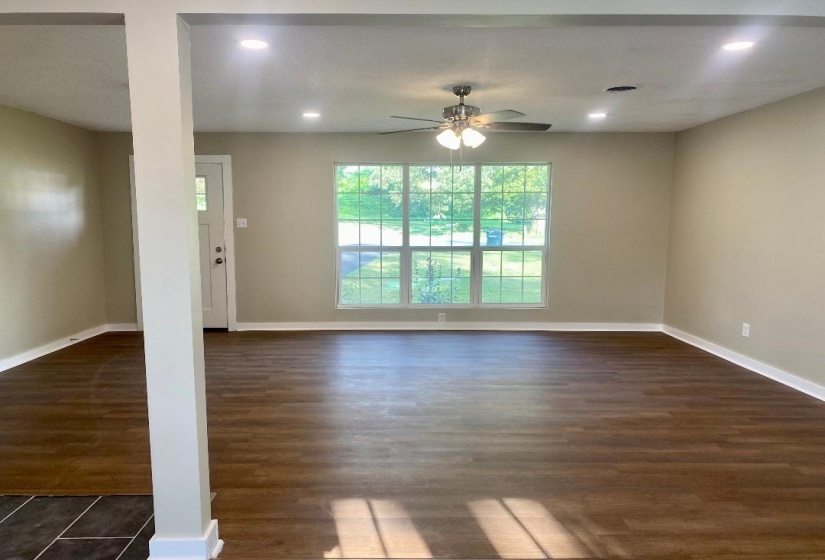 Unfurnished living room with dark wood-type flooring, ceiling fan, and recessed lighting