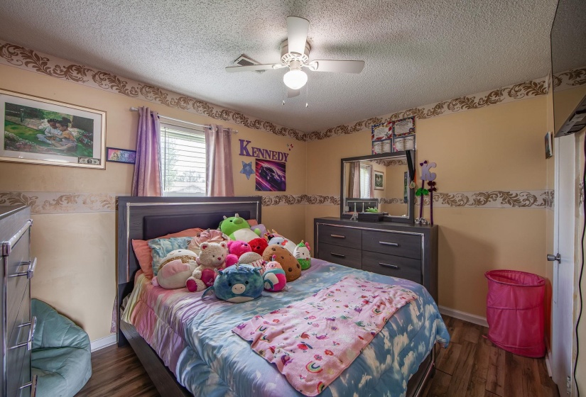 Bedroom featuring dark wood-style floors, a textured ceiling, and ceiling fan