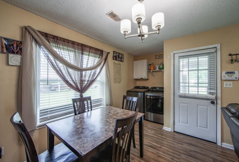 Dining space with a chandelier, washing machine and dryer, dark wood finished floors, and a textured ceiling