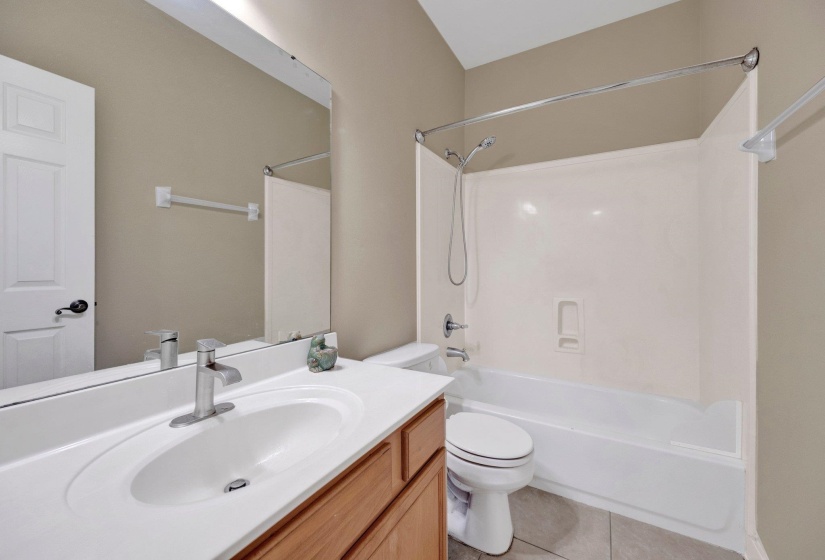 Full bath with vanity, shower / bath combination, and tile patterned flooring