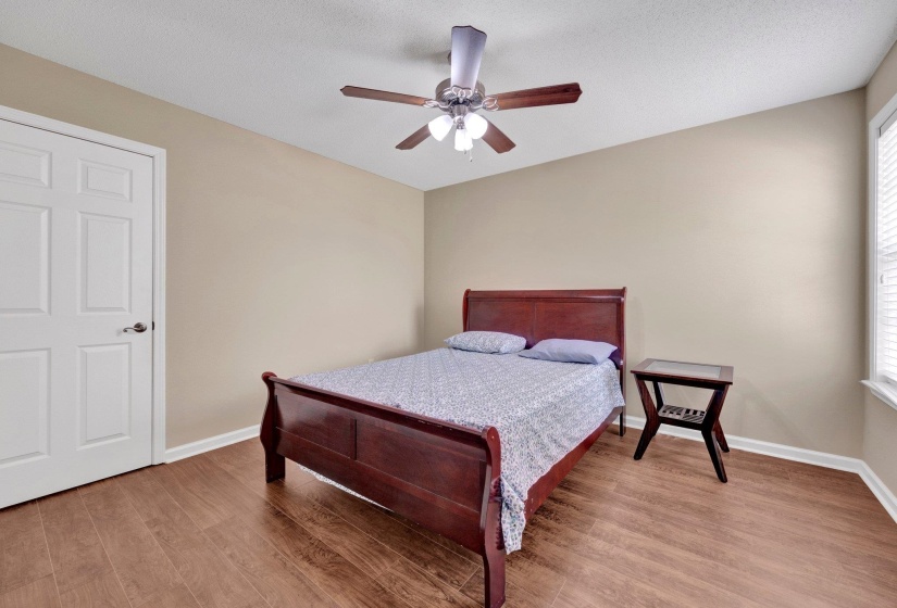 Bedroom featuring light wood-style flooring, multiple windows, and ceiling fan