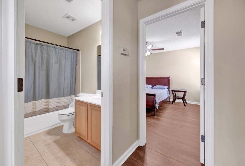 Bathroom featuring vanity, a ceiling fan, shower / bath combination with curtain, and wood finished floors