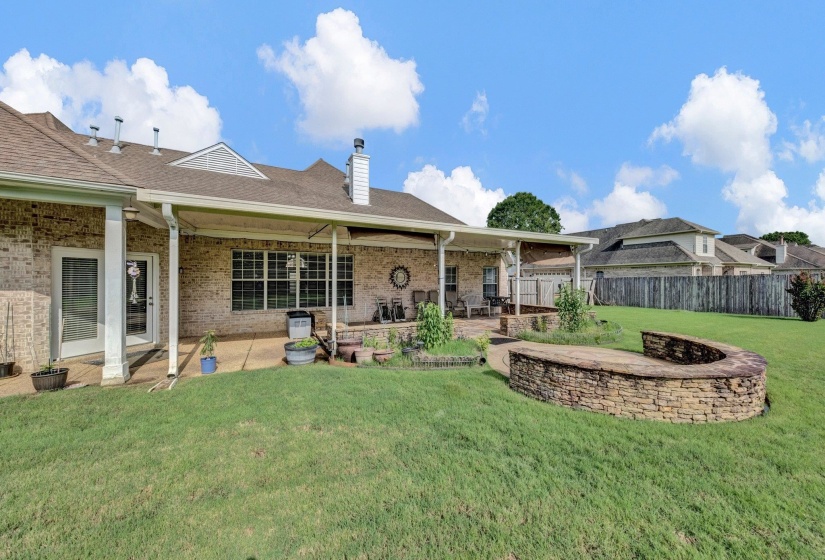Back of house with a patio, a chimney, brick siding, and a shingled roof