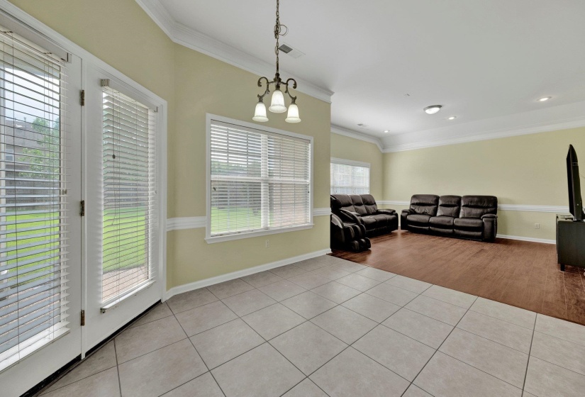 Living room featuring light tile patterned flooring, crown molding, and recessed lighting