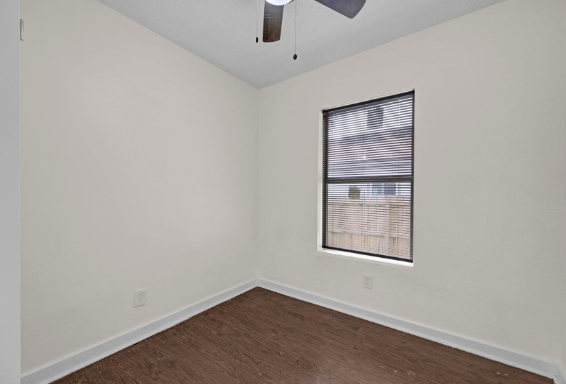 Empty room with dark wood-type flooring and ceiling fan