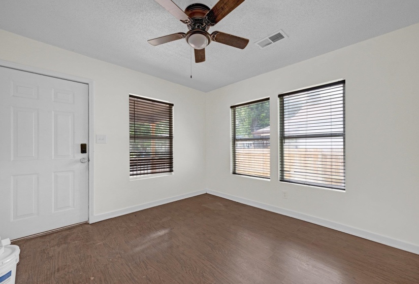 Spare room with dark wood-style flooring, ceiling fan, and a textured ceiling