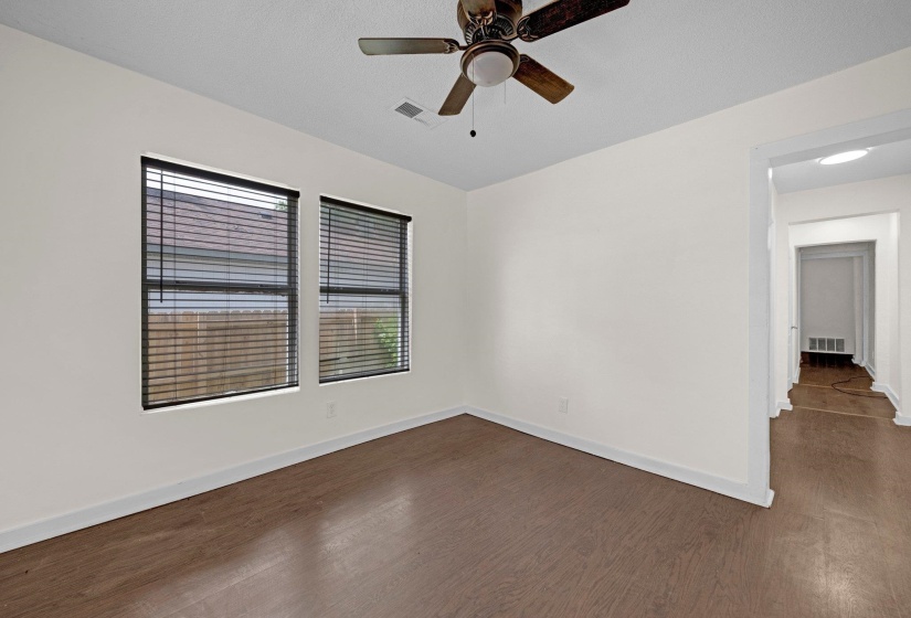 Empty room featuring dark wood finished floors and a ceiling fan