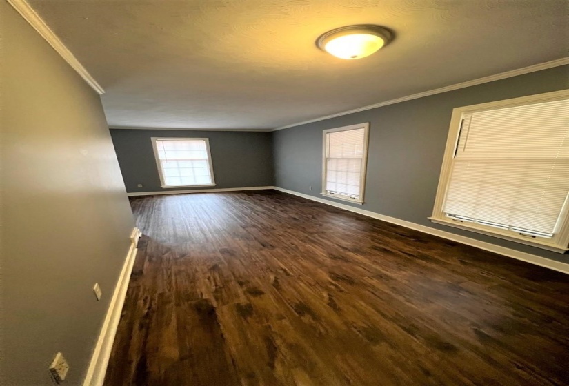 Empty room with ornamental molding and dark wood finished floors