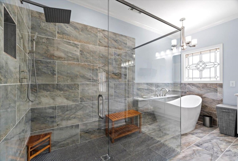 Bathroom with tile walls, crown molding, a freestanding bath, a stall shower, and a chandelier