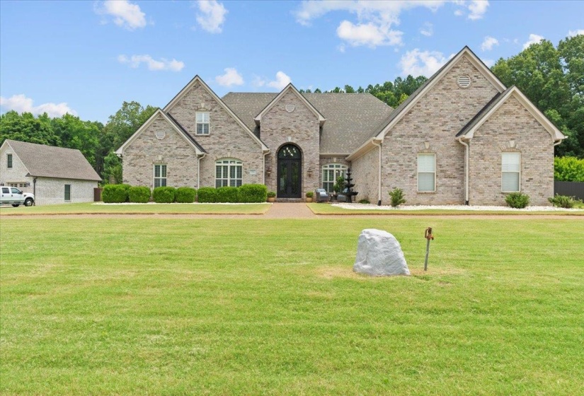 View of front facade featuring a front lawn and brick siding