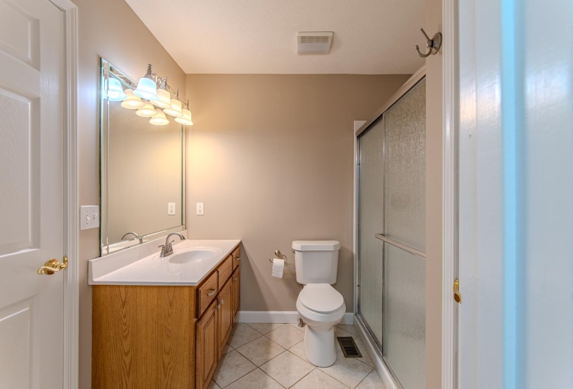 Full bathroom featuring tile patterned floors, vanity, and a stall shower