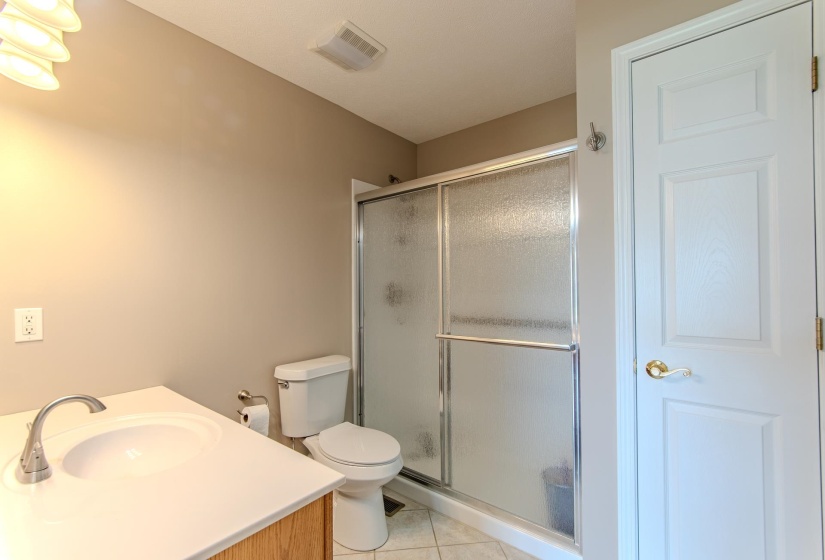 Bathroom with tile patterned floors, a stall shower, and vanity