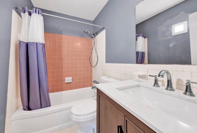 Full bathroom featuring shower / bath combo, vanity, tile walls, and tasteful backsplash