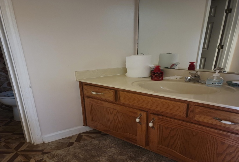 Bathroom featuring vanity, toilet, and baseboards