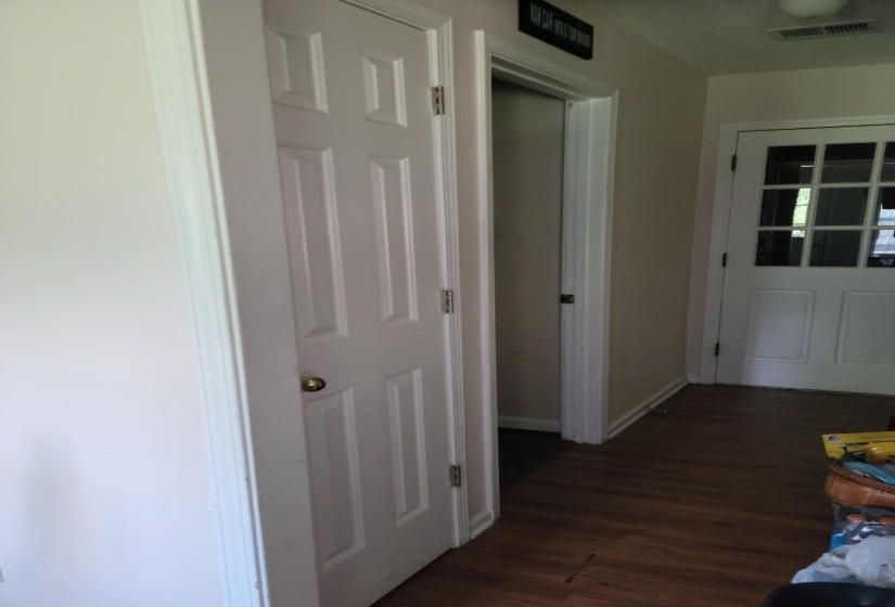 Corridor featuring dark wood-style flooring and baseboards