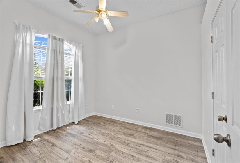 Spare room featuring dark wood-style flooring, a chandelier, and a tray ceiling