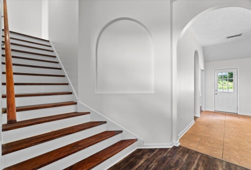 Empty room featuring vaulted ceiling, dark wood-style floors, and healthy amount of natural light